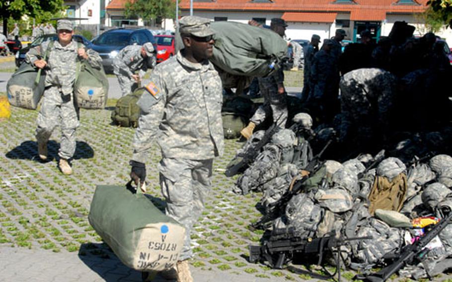 Soldiers from Company C, 1st Battalion, 4th Infantry Regiment load gear on a bus at Hohenfels, Germany, on Sunday for the first leg of a journey to Afghanistan.