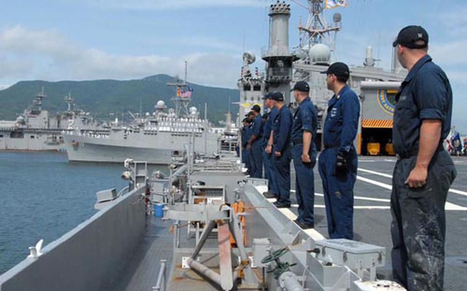 USS Denver sailors watch as the USS Juneau pulls into Sasebo Naval Base, Japan, on Thursday. The revitalized Denver will replace the Juneau next month.