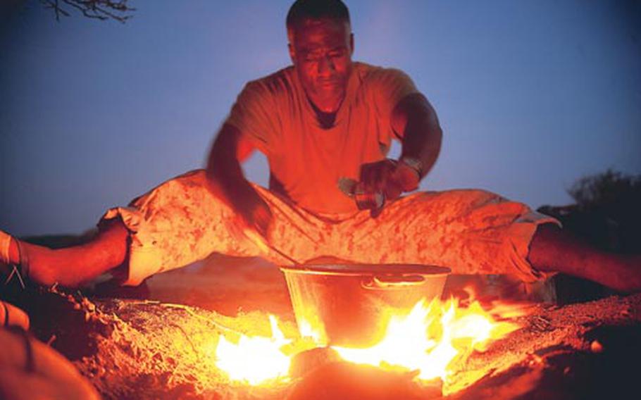 U.S. Navy Seabee Jean Joseph, assigned to Combined Joint Task Force-Horn of Africa, cooks goat meat for dinner during a 10-day French tactical desert survival training course. Forty U.S. Military members stationed at Camp Lemonier, Djibouti volunteered for the 10-day course taught by French marines of the 5th Regiment Overseas Infantry.