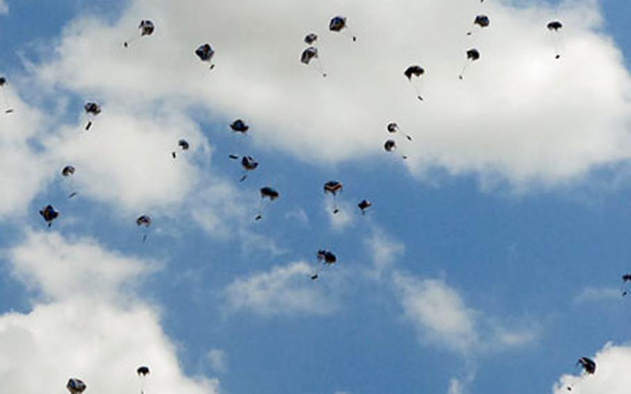 Hundreds of tiny parachutes bearing chocolate bars and chewing gum float to the ground after being dropped from a helicopter by Berlin Airlift veteran Gail Halvorsen.
