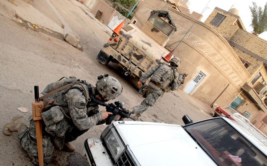 Soldiers from Company B, 1st Battalion, 502d Infantry Regiment patrol through the early morning streets of Shula on the way to the site of a supposed weapons cache.