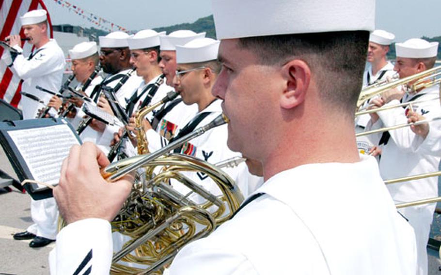 Petty Officer 1st Class Robert Booker, center, plays the French horn in the 7th Fleet band for the Change of Command ceremony Saturday. Outgoing commander Vice Admiral Doug Crowder called the band the fleet&#39;s "secret weapon."