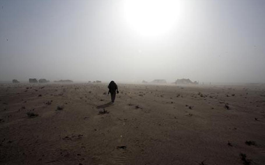 Lance Cpl. Andrew C. Fellows, a combat videographer with Marine Wing Support Squadron 172, walks through the Jazirah Desert.