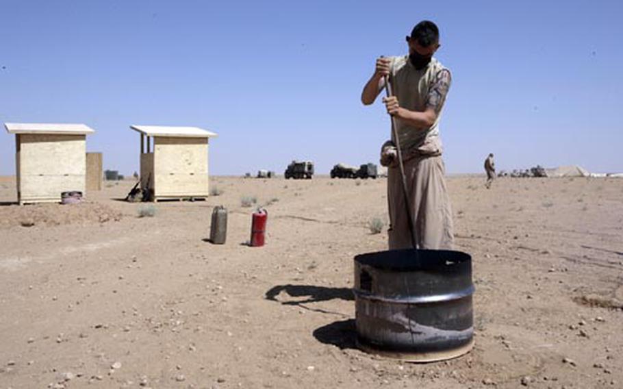 A Marine with Marine Wing Support Squadron 172 burns a mixture of JP8 Diesel Fuel and human waste at Rapid Refueling Point San Francisco in the Jazirah Desert in Anbar province, Iraq.