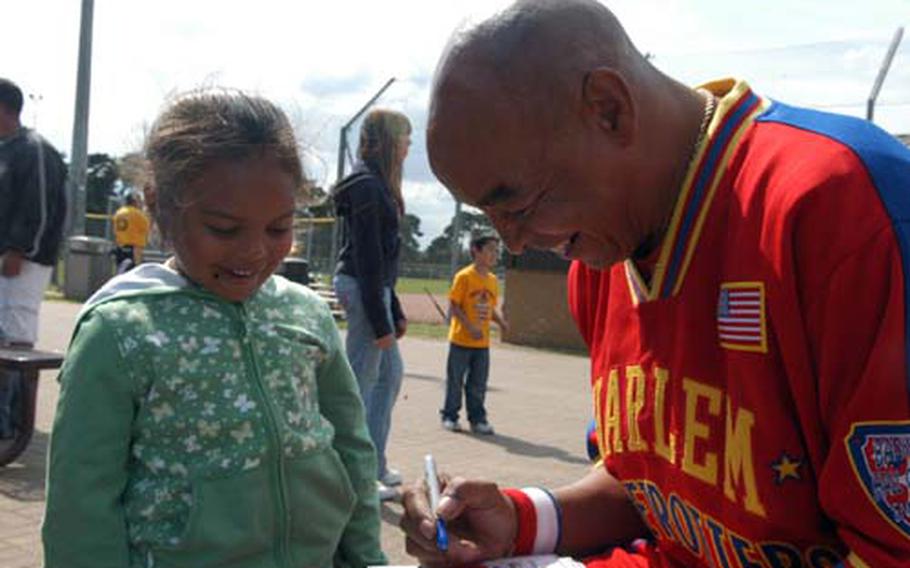 Curly Neal gives a fan his autograph last Saturday.