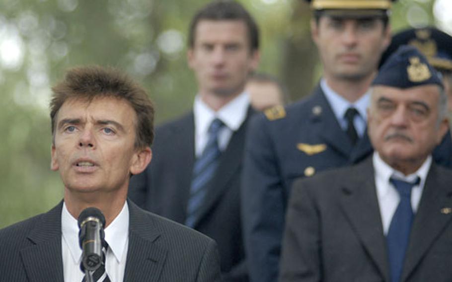 Klaus Layes, the mayor of Ramstein Villiage, speaks to a gathering during a ceremony Thursday to remember those who died 20 years prior in a devastating air show crash at Ramstein Air Base. Three aircraft from Italy&#39;s precision-flying team Frecce Tricolori collided during an aerial maneuver killing 67 bystanders and injuring more than 500 others. The three Italian pilots died.