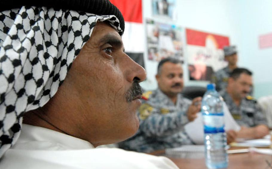 Qays Shther, an Arafiyah Sons of Iraq leader, listens to another leader speak Tuesday at a weekly meeting in Jisr Diyala run by Brig. Gen. Emad Ali Abd Ali, the senior National Police commander. Sons of Iraq groups in the area fall under National Police authority and work closely with Iraqi National Police liaisons.