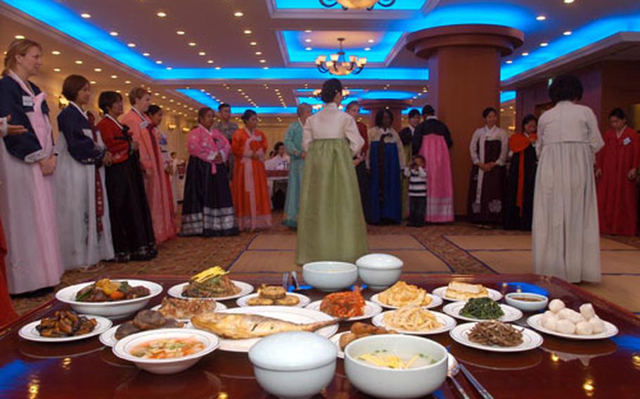 Camp Casey area employees and spouses learn Chuseok etiquette in front of a traditionally set table at the Yulim Hotel in Dongducheon, South Korea, on Thursday.