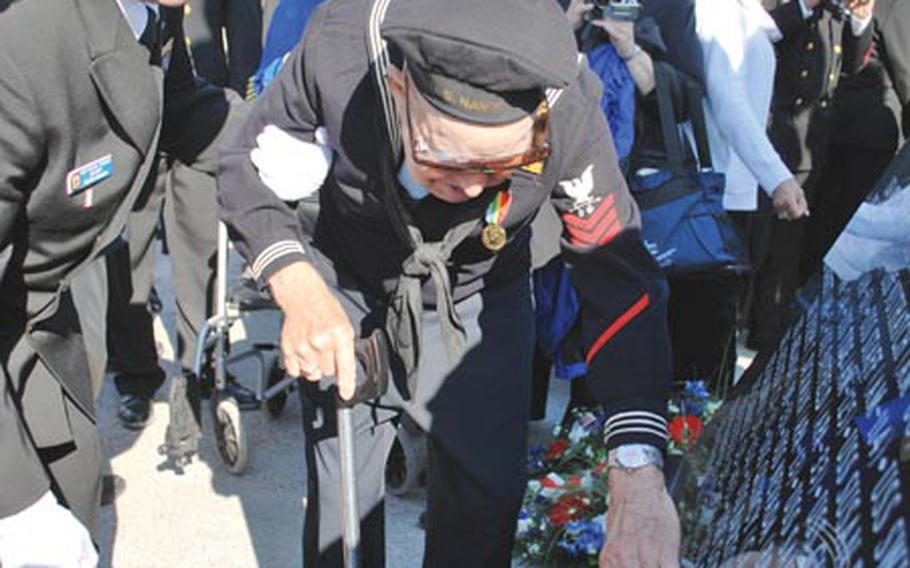 Don Krebs, 84, a U.S. Navy veteran of World War II who was at Normandy on D-Day, June 6, 1944, touches the name of his ship, the USS Harding, engraved in the base of a new memorial to the U.S. Navy at Utah Beach.