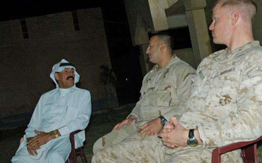 (from left to right) Sheikh Khalif Awad Farhan, translator "Sam" and Capt. Seth MacCutcheon discuss local issues following dinner at Farhan’s home. Meetings like this are common for the Marines at Combat Outpost Hit.