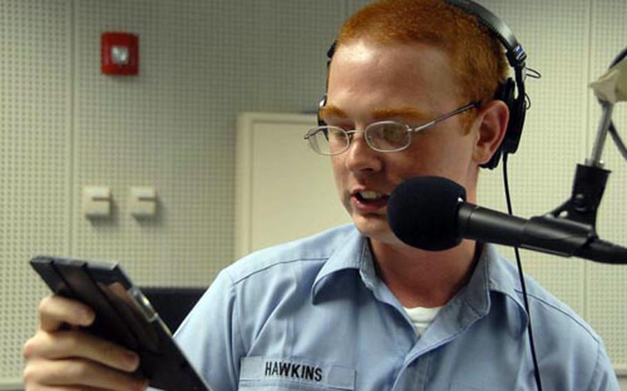 Seaman Jamie Hawkins looks over the song choices on an Armed Forces Radio and Television Service CD during his afternoon show at AFN Sasebo, Japan. The show airs from noon to 3 p.m. Monday through Friday.