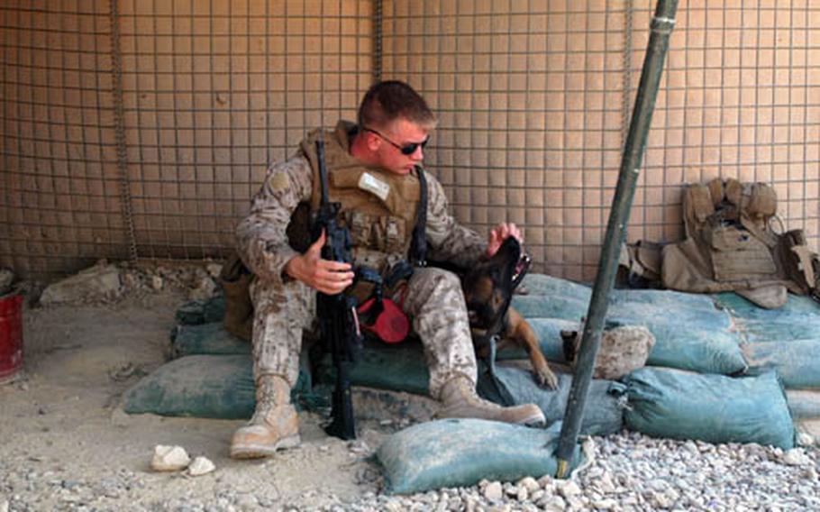 Lance Cpl. John Skordos, 3rd Battalion, 7th Marine Regiment and his cohort, Barasco, wait for a convoy headed to South Hit, Iraq, Friday after insurgents fired at Marines in the area.