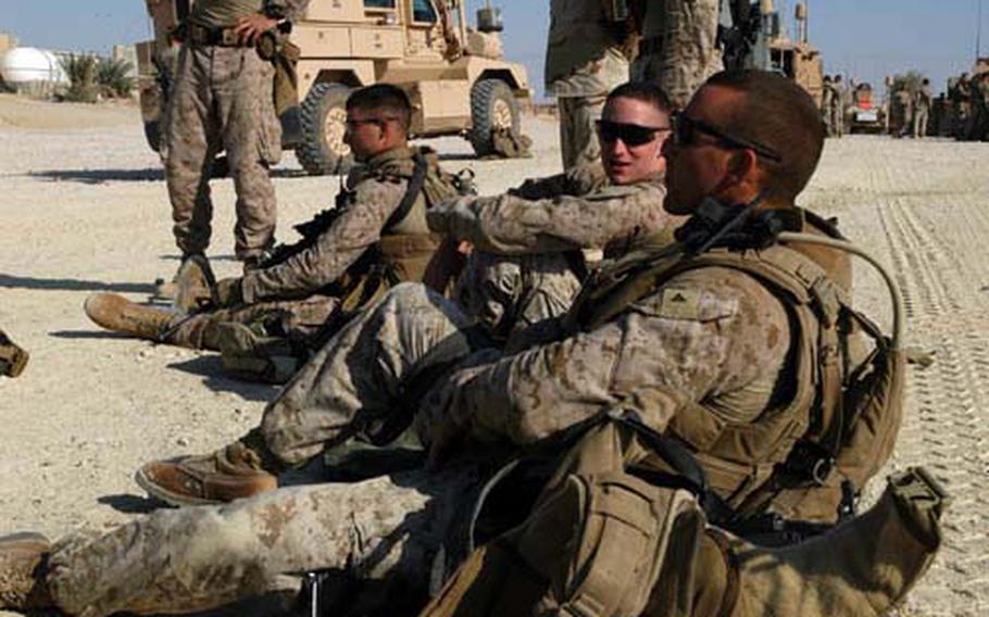 Right to left, Lance Cpl. Benjamin Kelly, Lance Cpl. Joel McLaughlin and Staff Sgt. Ryan Nikzad, with L Company, 3rd Battalion, 7th Marine Regmient, wait to board trucks in a convoy headed to South Hit, Iraq, after a shooting there Friday.