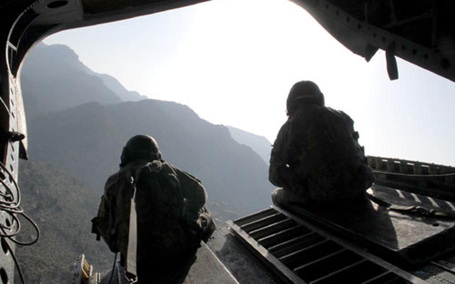 Soldiers from the 101st Aviation Regiment scan the ground from the back of a Chinook helicopter over Khost province in eastern Afghanistan. Commanders say insurgents have made a bid to establish a significant base of operations this year in Khost, which borders Pakistan, and that a growing number of foreign fighters are coming across the border.