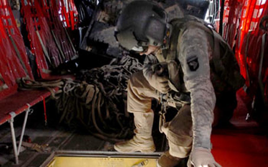 Operating in Afghanistan&#39;s remote eastern mountains presents many challenges to American troops. With few roads, most units rely on helicopters to ferry in supplies. Here, a Chinook crewmembers prepares to attach a sling-load at a base in Konar province.