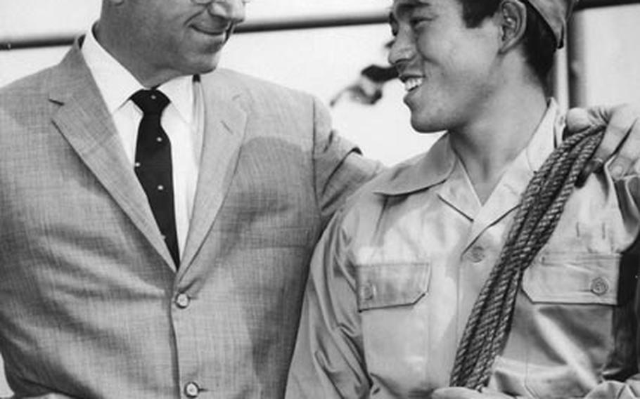 Novelist James A. Michener poses with Chiba Yoshikatsu, a 19-year-old Japanese soldier who helped rescue Michener and other survivors of a plane crash a few days earlier off Iwo Jima. Yoshikatsu swam 150 yards through shark-infested waters to bring a tow line to the raft of Michener and 11 Air Force men after their C-47 ditched at sea.