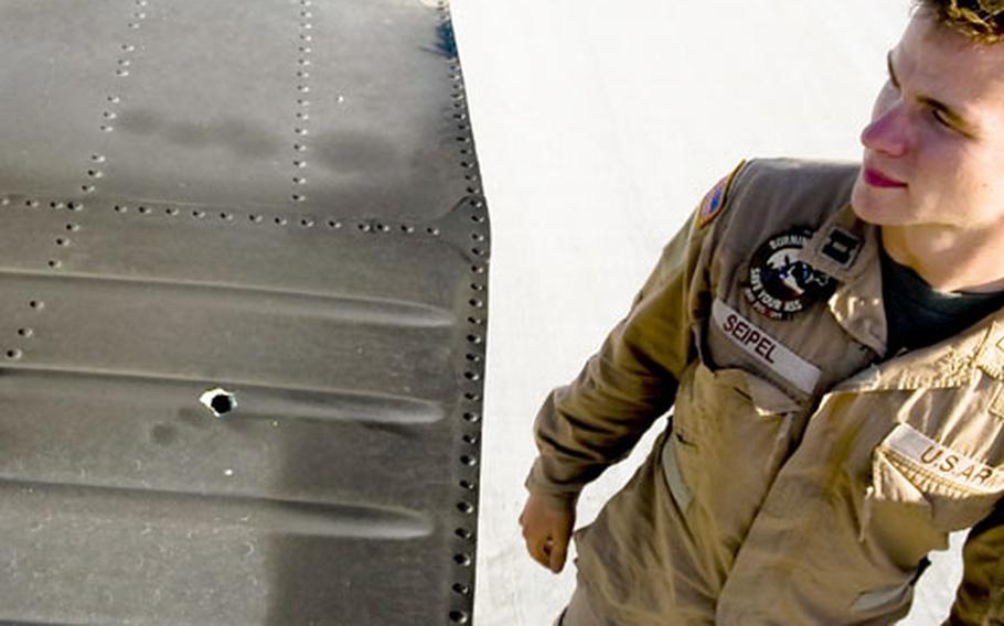 Capt. Ben Seipel, a helicopter medevac pilot based in Jalalabad, inspects a bullet hole in the tail of his Black Hawk helicopter after a mission to pick up a wounded soldier in Konar Province. U.S. medevac helicopters regularly come under fire from insurgents and also face more exotic threats, including wires strung between mountain peaks in an effort to snag the aircraft. The medevac helicopters are usually accompanied by Apache gunships but themselves go unarmed, with red crosses painted on the doors. "The Geneva Conventions were definitely violated again," Seipel joked.