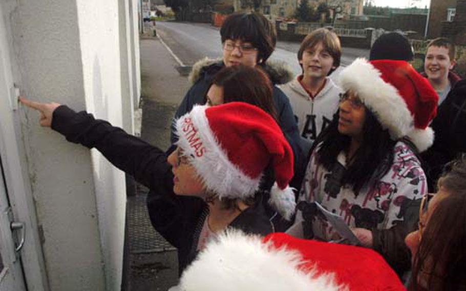 Sixth-grader Sam Louque presses the doorbell of a Feltwell resident she and her classmates supplied with a Christmas care package Friday.