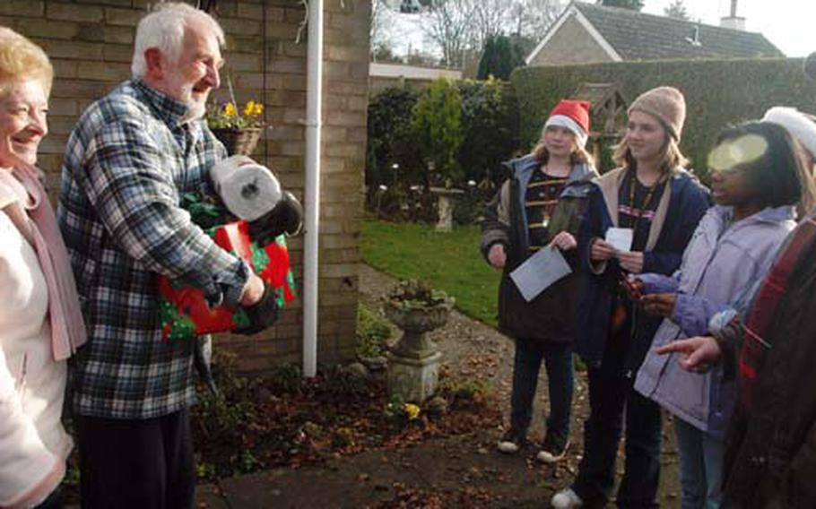 Two residents of Feltwell smile to Lakenheath Middle School sixth-graders who delivered gifts of household items to elderly members of the community.