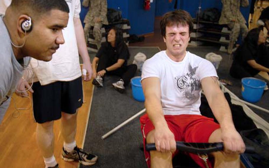 Steve Laub, a contractor at Ramstein Air Base, pulls hard at the end of a high-impact, 23-minute workout Wednesday as Tech Sgt. Jose Rivera looks on.