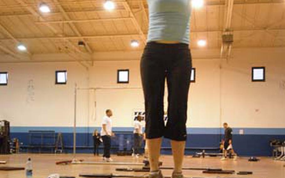 Laura Langevin leaps up during a set of “burpees,” mixing push-ups, squats and leaps.