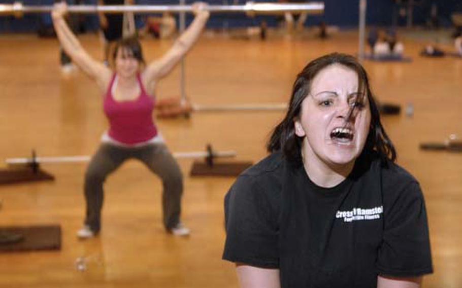 Airman 1st Class Tracie Weaks, a reservist assigned to Detachment 2, 693rd Inspector General, shouts out during a set of 35 pound kettle bell over-head swings.