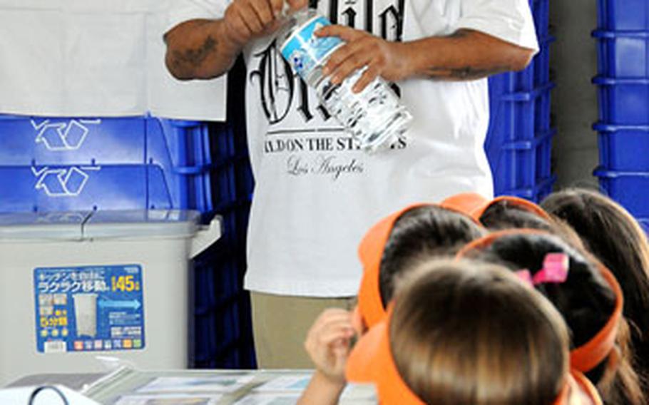 Jeff Strain, a Camp Foster Recycling Center worker, tells a group of third-graders from Kinser Elementary School that when they recycle plastic bottles, they should remove the caps, so center workers don&#39;t spend all day removing thousands of capss instead of doing other recycling work.