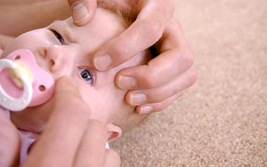 Air Force Tech. Sgt. Ross Funches points out the coloboma, which has distorted the shape of his daughter Eden’s pupil and caused her to be blind. She was diagnosed with the disorder shortly after she was born in April 2008.