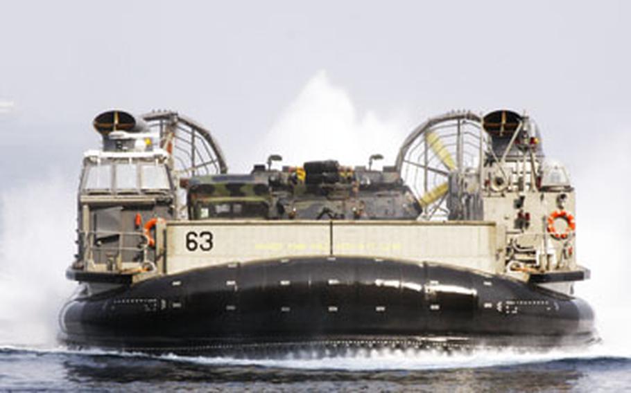 An LCAC hovercraft roars into the well deck of the amphibious assault ship USS Essex