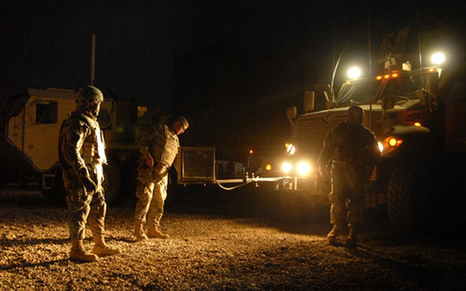 Pfc. Brandon Turcotte, center, and Spc. Brian Craytor, left, both soldiers assigned to the 172nd Support Battalion, prepare an MRAP as part of a security team for a large vehicle convoy to Forward Operating Base Iskan late Monday night at FOB Kalsu. The 172nd is responsible for transporting vehicles and cargo containers from Iskan as U.S. forces ready the FOB for over transfer over to the Iraqi Ministry of Electricity within the month.