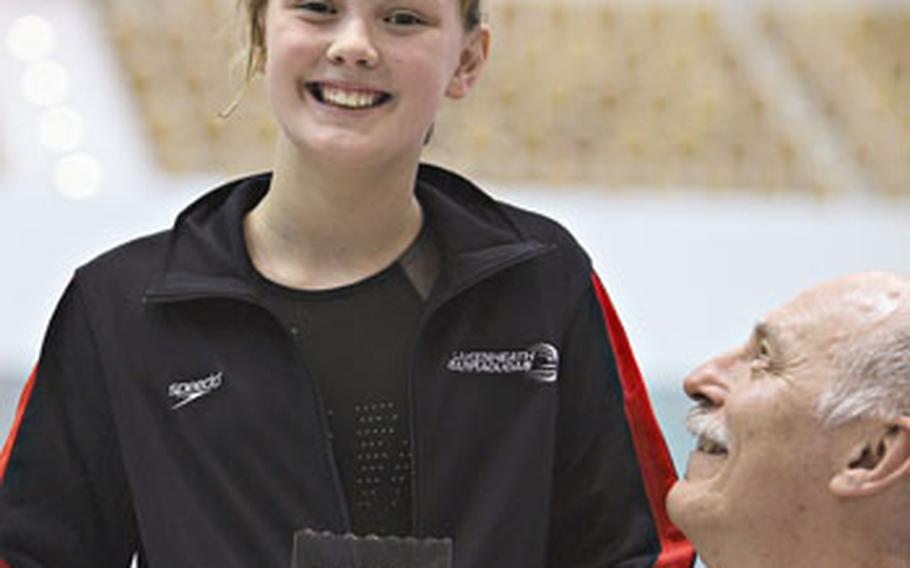 Dominic’s sister, Alaina, 11, receives an award for highest points in her age group at the championships. The award was presented by Steve Genter, right, a 1972 Olympic gold medal swimmer. Alaina grabbed fived gold medals at the event.