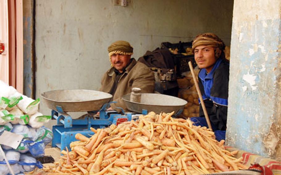 Two men sit at a food stand in the market in downtown Rutbah, which U.S. Marines say used to be full of insurgents. The city is mostly calm now, with little insurgent violence.