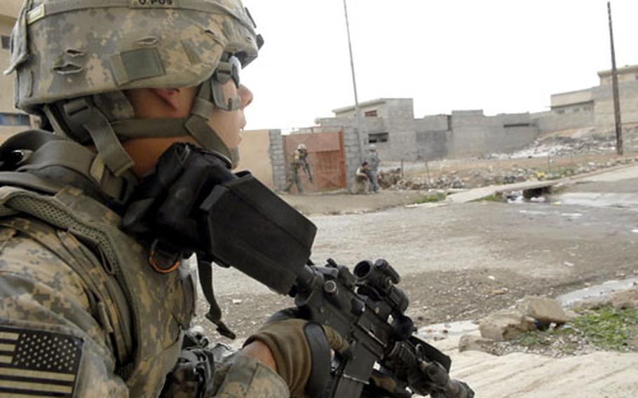 A U.S. soldier peeks out from behind a wall during a recent gunfight in Mosul.