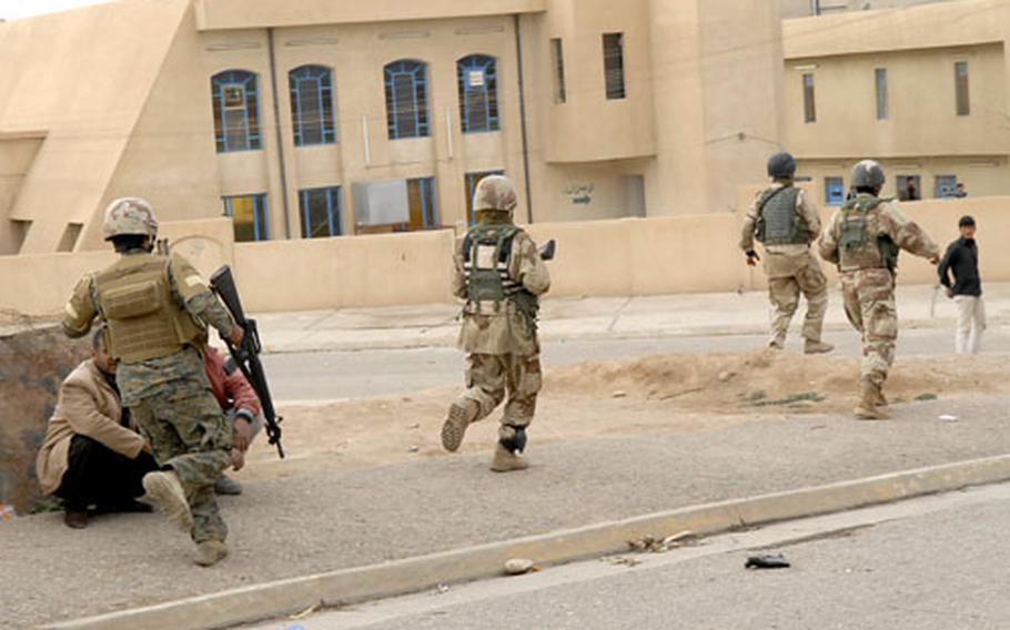 Iraqi soldiers run for cover while under fire in Mosul’s Saddam neighborhood.