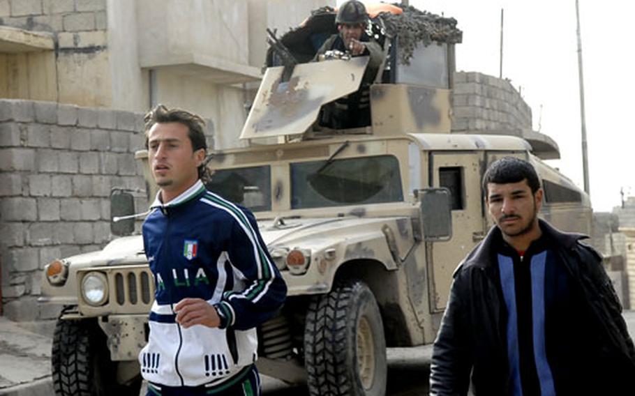 Iraqi soldiers use Humvees to round up men for questioning in Mosul after an Iraqi soldier was shot at a nearby checkpoint.