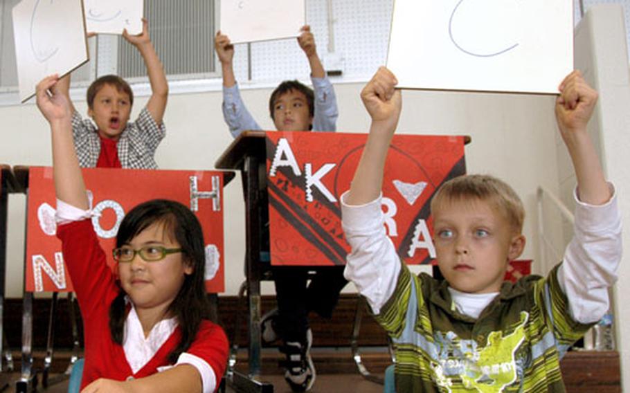 Members of the Firebird class hold up answers to a quiz question Thursday during a game of “Are you smarter than a Firebird?” at Amelia Earhart Intermediate School at Kadena Air Base on Okinawa.