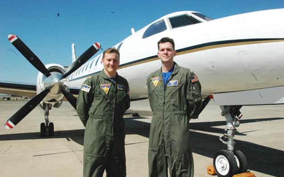 Lt. Cmdr. Bill Roark, left, and Lt. Danny Abad, both Navy pilots, stand in front of one of two C-26 Metroliner aircraft stationed at Naval Air Station Sigonella, Sicily. The aircraft are used for rapid transport of passengers and cargo through the European theater. Two other aircraft are based in Naples, Italy.