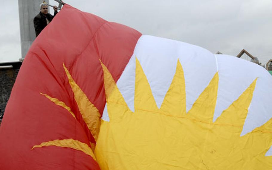 A worker raises the Kurdish flag outside the Kurdistan National Assembly building in Irbil.