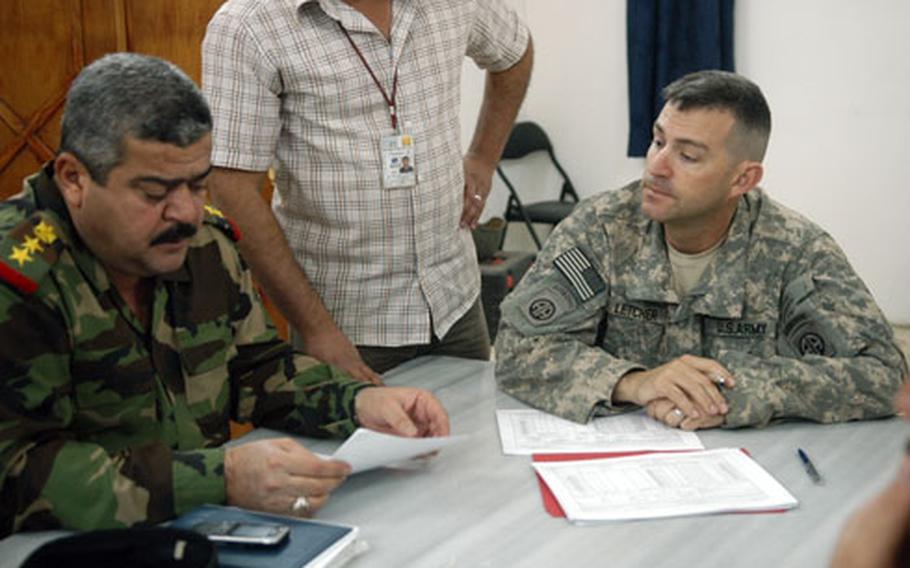 Army Maj. Ken Letcher, right, of the 82nd Brigade Support Battalion, signs papers transitioning control of Forward Operating Base Rustamiyah to Iraqi control with Iraqi Col. Jassim Mohamed Jaber.