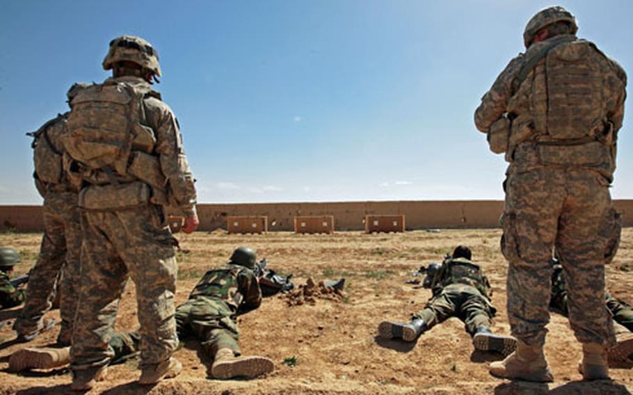 Spc. Steven Krienke, 22, of Federal Way, Wash., and Spc. Michael Alfassa, of Los Angeles, observe Afghan troops as they try to zero their weapons.