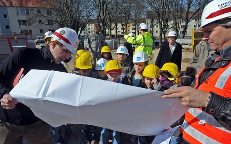 Ben Peschke, left, a project engineer, and Neil Ravensbergen, the resident engineer for the U.S. Army Corps of Engineers in Wiesbaden, Germany, show Aukamm Elementary School second-graders the plans for a new multipurpose facility for the middle school at Hainerberg housing area.