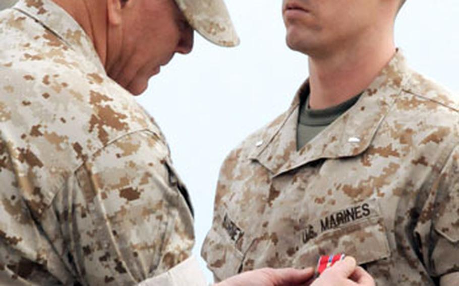 Lt. Gen. Richard C. Zilmer, left, commander of III Marine Expeditionary Force and Marine Corps Bases Japan, pins a Bronze Star Medal with V to 1st Lt. Christopher J. Kearney&#39;s chest during the ceremony at Camp Schwab.