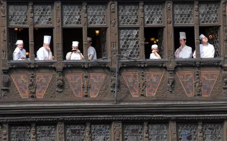 The kitchen staff looks out the windows of the 15th-century Maison Kammerzell on Strasbourg, France&#39;s cathedral square, hoping to catch a glimpse of U.S. President Barack Obama and President Nicolas Sarkozy of France, following their meeting at the Rohan Palace on Friday morning. The crowd lining the square only got to see the presidents&#39; motorcades roll by.