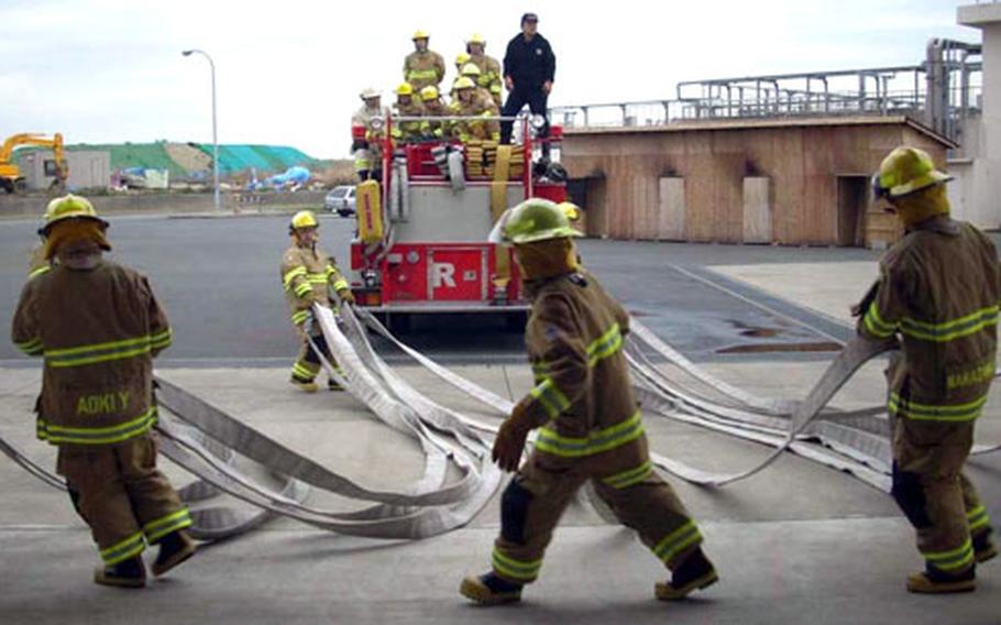 Rookie recruits haul hoses during an intensive eight-week program March 24 at Yokosuka Naval Base. Japanese citizens enter the “Rookie Academy” to become firefighters on U.S. Navy installations in Japan. These recruits, if they graduate, will be stationed along the Kanto Plain in central Japan.