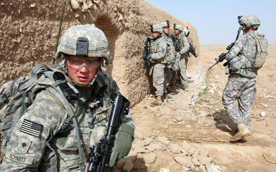 Spc. Jacob Schmitt, 20, of Grand Forks, N.D., and other soldiers from Company B, 2nd Battalion, 2nd Infantry Regiment take up security positions before searching a compound for Taliban arms and munitions in the villlage of Mowshaq, Maiwand district, Kandahar province, Afghanistan. The soldiers were carrying out the search after a series of nearby roadside bombings, but they found nothing in the village.