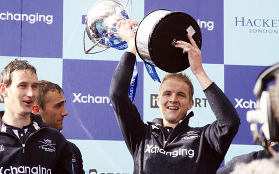 George Bridgewater lifts the trophy that Oxford took home after the university boat race against Cambridge on March 29 along the Thames in London.