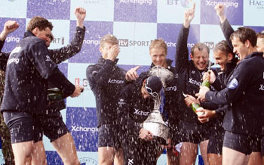 After winning the annual university boat race on March 29, Oxford rowers revel upon receiving their trophy, which they took turns passing around and even kissing in some cases.