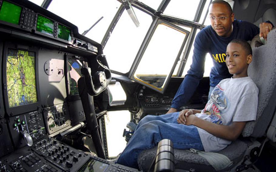 Anthony Clark, 10, and his dad, Air Force Staff Sgt. Shaun Clark, check out the new C-130J&#39;s cockpit Tuesday at Ramstein Air Base&#39;s flight line. The first of 14 new cargo planes arrived with Gen. Roger Brady, commander of U.S. Air Forces in Europe, at the controls. Anthony said he wants to join the Air Force when he is old enough.