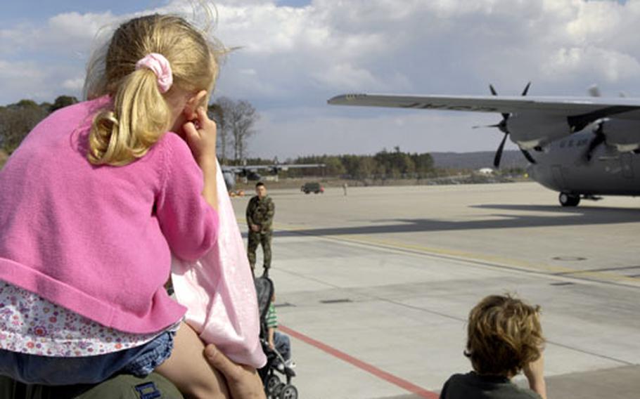 Hallie Kinion, 3, on the shoulders of her dad, Capt. Troy Kinion, plugs her ears as the new C-130 J model pulls into its parking space Tuesday at Ramstein Air Base&#39;s flight line. Kinion, an officer assigned to the 86th Aeromedical Evacuation Squadron, said that the new plane will be the primary aircraft used for the unit&#39;s medical mission.
