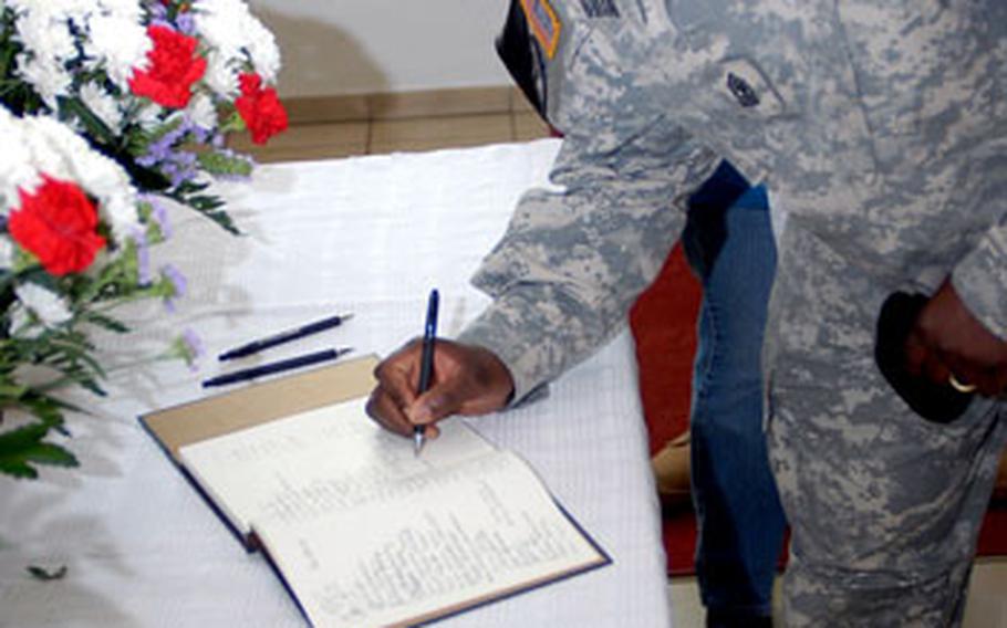 First Sgt. Hassan Wilson, Headquarters and Headquarters Company, U.S. Army Garrison Schweinfurt, signs a condolence book at the memorial ceremony.